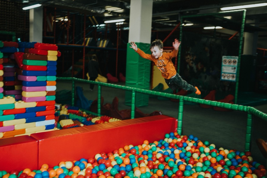 Child jumping into a ball pit at a trampoline park
